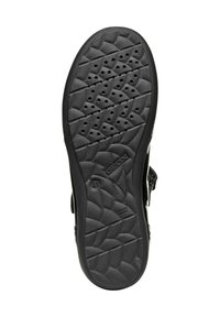 Black rubber shoe sole featuring a textured surface with a geometric pattern, ventilation holes, and embossed brand logo.