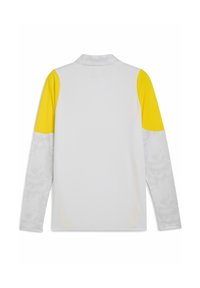 Vit långärmad skjorta med gula accenter på axlarna. Den har ett strukturerat vitt mönster på ärmarna. Krage och rak fåll.