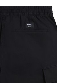 Shorts noirs Vans avec une taille élastique, une poche passepoilée à l'arrière, une poche cargo et une étiquette avec le logo Vans au-dessus de la poche arrière.