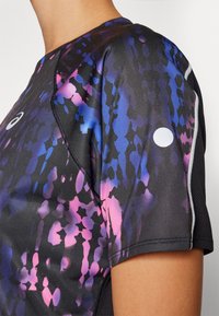 Camisa desportiva de mangas curtas com uma base preta, featuring um padrão abstrato vibrante em azul e rosa. Inclui detalhes refletivos e um logotipo.