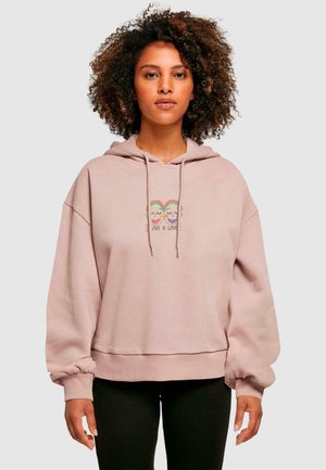 Lys rosa oversized hettegenser laget av mykt stoff, med et frontgrafikk med regnbueakkenter og teksten "KJÆRLIGHET ER KJÆRLIGHET." Forhåndskrympet design.