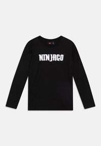 Schwarzes langärmeliges T-Shirt aus Baumwolle mit einem auffälligen weißen "NINJAGO"-Logo, das quer über die Brust gedruckt ist. Klassisches Rundhalsdesign.