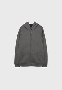 Sweat à capuche zippé gris en tissu doux avec une capuche spacieuse, des poches avant et des poignets et un ourlet côtelés. Texture lisse, coupe décontractée.