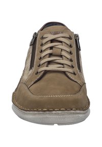 Beige kožené tenisky s texturovanými bočními panely, kontrastními šňůrkami a dvojicí zipů pro snadný přístup. Kulatá špička a gumová podrážka.