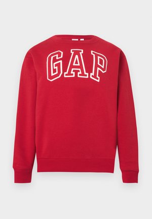Felpa rossa a maniche lunghe con polsini e orlo a coste, con grandi lettere contornate di bianco che formano la scritta "GAP" sul petto.