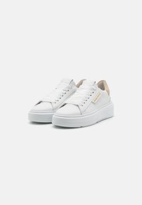 Adidași albi cu un superior din piele texturată, șireturi plate albe și o talpă joasă. Cureaua de la călcâi are un accent bej. Detaliu din hardware aurie.