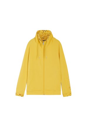 Gul zip-up huvtröja med blommönstrad foder i huvan och ärmsluten. Har dragsko och ribbad nederkant. Mjuk tygtextur.