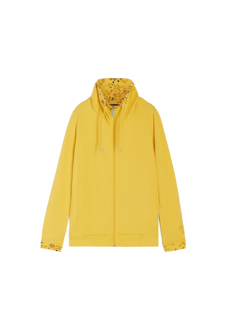 Felpa gialla con zip, con una fodera a stampa floreale nel cappuccio e nei polsini. Presenta delle stringhe e un orlo a coste. Tessuto morbido.
