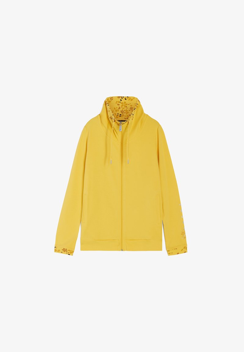 Felpa gialla con zip, con una fodera a stampa floreale nel cappuccio e nei polsini. Presenta delle stringhe e un orlo a coste. Tessuto morbido.