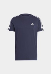 Mornarica majica od pamuka s kratkim rukavima, bijeli trostruki akcenti na ramenima i mali bijeli Adidas logo na prsima.