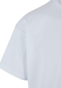 Hvid bomulds T-shirt med korte ærmer, rund halsudskæring og glat tekstur. Synlig syning og klassisk pasform. Enkel, udekoreret design.