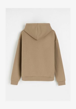 Brązowa, kapturowa bluza o luźnym kroju. Wykonana z miękkiej, teksturowanej tkaniny, z długimi rękawami i ściągaczem na dole. Widok z tyłu.