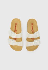 Bele sandale z dvema nastavljivima sponkama, teksturiranimi iridescentnimi trakovi in rjavimi oblazinjenimi vložki. Vidno je ime blagovne znamke "superfit".