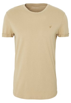 Beżowy t-shirt z krótkim rękawem i okrągłym dekoltem, z małym wyszywanym logo na lewej piersi i podwiniętymi mankietami.