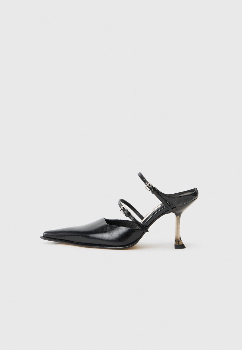 Black leather point-toe slingback shoe with two adjustable straps and a metallic heel. Smooth texture and minimalist design.