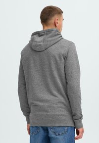 Grå hettegenser i myk, strukturert stoff med en frontlomme i kengurustil, ribbestrikkede mansjetter og nederkant, og med en hette med snor.