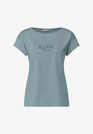 T-shirt en coton bleu clair à manches courtes. Présente un col rond et un texte imprimé : "ICONIC Confidence" accompagné de phrases supplémentaires en dessous.
