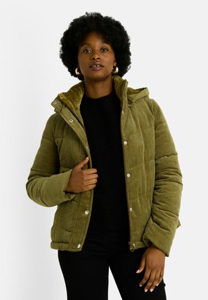 Chaqueta de plumas de pana verde oliva con capucha, cierres delanteros a presión, textura acanalada y corte entallado, llevada sobre un suéter negro.