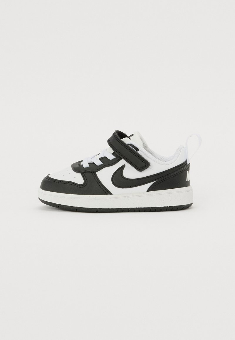 Sapatilha em preto e branco com upper em couro e malha, faixa ajustável em Velcro, atacadores brancos e colarinho acolchoado para conforto.