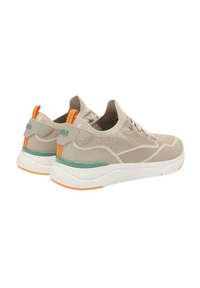 Zapatillas de malla beige con suelas blancas, con detalles verdes y pestañas en el talón de color naranja. Diseño ligero con tejido texturizado para mayor transpirabilidad.