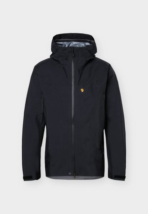 Čierna nepremokavá bunda s kapucňou, predným zipsom, suchými zipsami na zápästiach, bočnými vreckami a malým žltým logom na ľavej strane hrudníka.