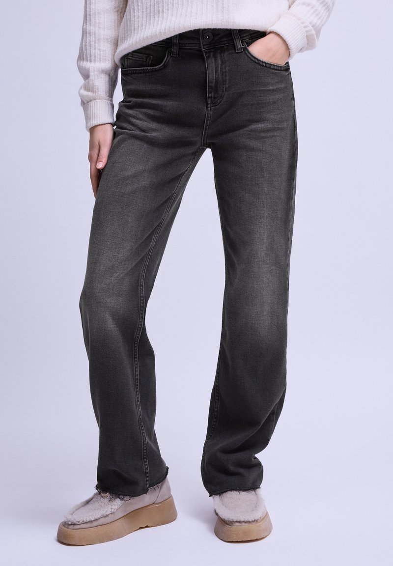 Jeans de mezclilla negros con un ajuste recto, que presentan un cierre frontal de botón, diseño de cinco bolsillos y un ligero desvanecimiento.