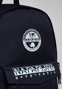 Zaino in tessuto blu navy con un logo circolare che rappresenta un globo e l'Antartide. Testo bianco in grassetto "NAPAPIJRI" su una pattina nera con accenti a contrasto.