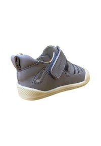 Sandalia infantil de cuero gris con diseños troquelados, correa ajustable de Velcro y suela de goma blanca con un patrón texturizado.