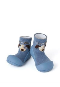 Calcetines de punto azules con un diseño de perro; suelas de goma, tejido texturizado y adornados con el nombre "CHARLIE" en costura marrón claro.