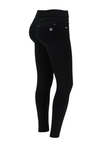 Leggings negros elásticos con cintura de media altura, dos bolsillos traseros con detalles plateados y un diseño ajustado que proporciona una silueta esbelta.