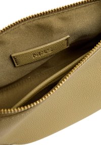 Funda de cuero texturizado verde oliva con un interior suave, cremallera dorada y una etiqueta en relieve. El interior presenta un forro de tela beige.