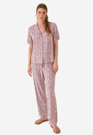 Ensemble de pyjama à motifs floraux en rose et blanc, comprenant un haut à manches courtes avec boutons et un pantalon long ample à coupe décontractée.