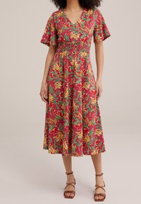 Czerwona, kwiecista sukienka midi z krótkimi falbaniastymi rękawami, z marszczoną talią i misternymi żółtymi oraz zielonymi wzorami liści.