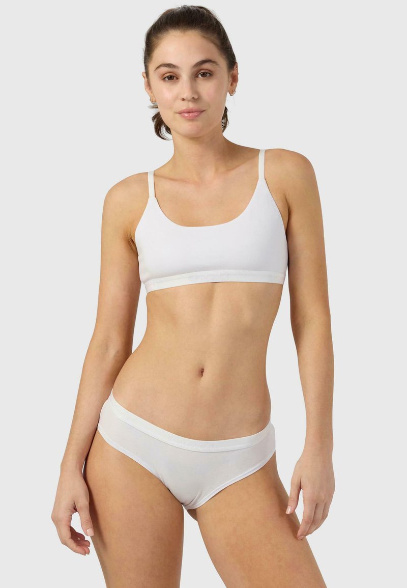 Balta kokvilnas bralette ar plānām siksnām un elastīgu joslu; atbilstošas baltas hipster apakšbikses ar mīkstu jostu; bezšuvju dizains.