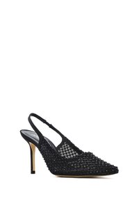 Zwart mesh pumps met slingback en hoge hak, met een puntige neus en een bovenwerk met textuur, beige zool en dunne stilettohak.