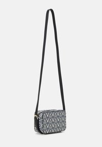 Crossbody bag in geometric pattern with black fabric strap, rectangular shape, zip closure, and synthetic material in shades of blue and cream.