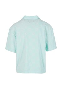 Camisa polo de manga corta en verde menta claro, con una superficie texturizada y un patrón, y un cuello clásico.