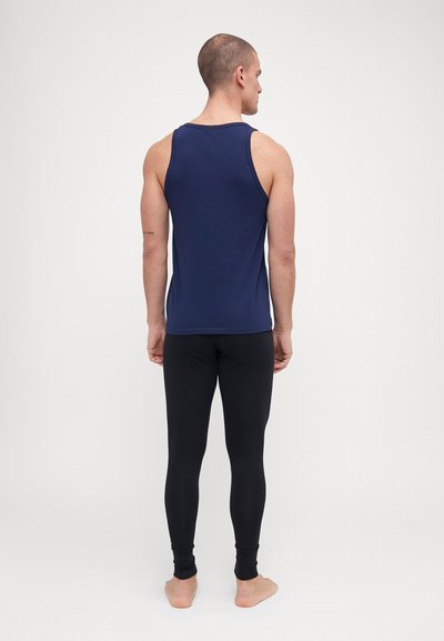 Marineblå tank topp laget av mykt stoff, kombinert med svarte tettsittende leggings, med et stilrent design og minimal detaljering.