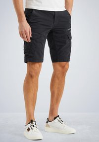 Bermudas negras de trabajo hechas de un tejido duradero, con múltiples bolsillos laterales, un ajuste relajado y una etiqueta de marca sutil en el frente.