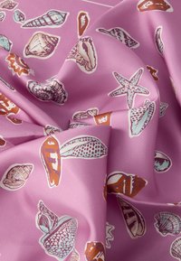 Textile présentant un fond rose pâle avec des motifs de coquillages et d'étoiles de mer en blanc, bleu et marron, texture lisse et finition brillante.