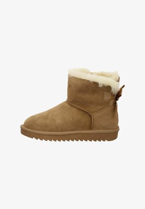 Botte de cheville en suede marron avec une douce doublure en shearling crème, semelle plate et accent à toggle sur le côté. Tige texturée et coutures décoratives.