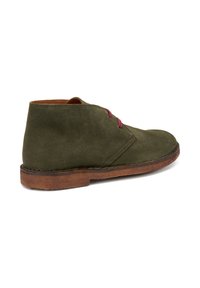Stivale chukka in suede verde oliva con punta rotonda e lacci bordeaux, dotato di suola in pelle marrone e design semplice ed elegante.