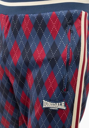 Red and navy argyle-patterned joggers with an elastic waistband, side zipper pocket, and a Lonsdale London logo patch.