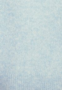 Tissu de pull tricoté bleu clair, présentant une texture douce avec un motif légèrement chiné, montrant des détails de points réguliers et un ourlet côtelé.