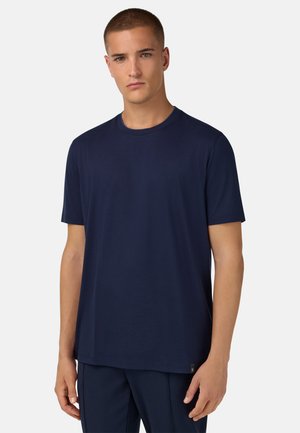 Marineblaues T-Shirt mit kurzen Ärmeln aus weicher Baumwolle, mit rundem Ausschnitt und einem dezenten Logotag am unteren linken Saum.