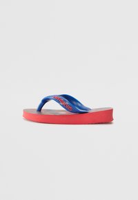 Blå gummi flip-flop med en teksturert såle og en rød såle. Har en blå stropp med merkevarenavnet trykt i rødt.