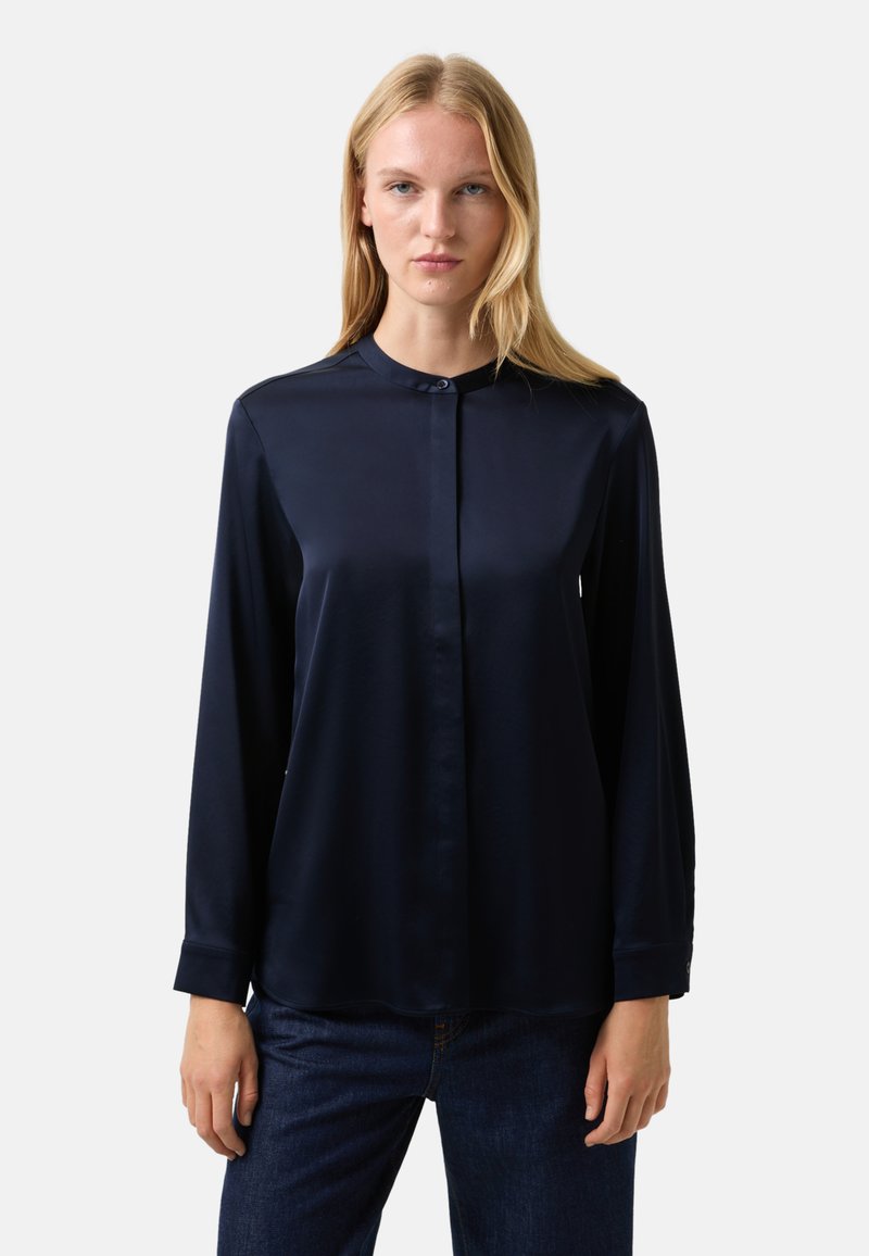 Marineblauwe satijnen blouse met een knoopsluiting aan de voorkant, een klassieke kraag en lange mouwen, voorzien van een gladde textuur en een ontspannen pasvorm.