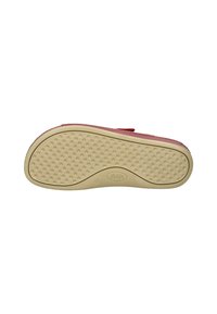 Chaussures rouges avec un dessus texturé et une semelle en caoutchouc beige présentant des motifs de grip circulaires. Bride Velcro pour un ajustement.