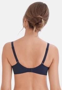 Reggiseno blu navy con spalline regolabili, texture liscia, bordi scallop e chiusura a gancio e asola sul retro.