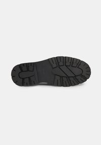 Zwarte rubberen zool met diepe, gestructureerde loopprofielen voor grip. Kenmerkt zich door een ronde vorm en een lichte kromming voor stabiliteit. Duurzaam materiaal.